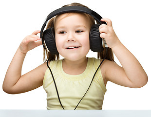 Image showing Little girl is enjoying music using headphones