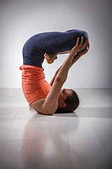 Image showing Sporty fit woman practices inverted yoga asana