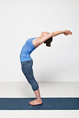 Image showing Sporty fit woman practices yoga asana Anuvittasana