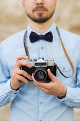 Image showing close up of hipster man with film camera in city