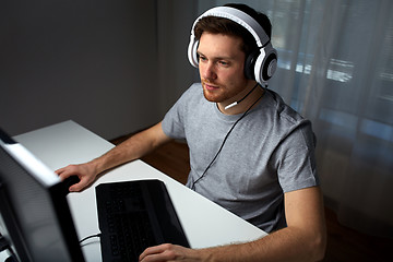 Image showing man in headset playing computer video game at home