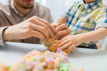 Image showing father and son playing with ball clay at home