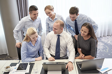 Image showing smiling business people with laptop in office