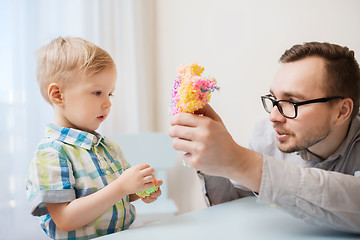 Image showing father and son playing with ball clay at home