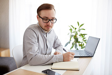 Image showing creative man or businessman writing to notebook