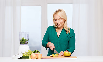 Image showing smiling woman with blender cooking food at home