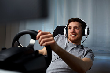 Image showing man playing car racing video game at home