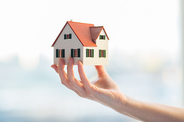 Image showing close up of hands holding house or home model