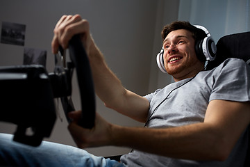 Image showing man playing car racing video game at home