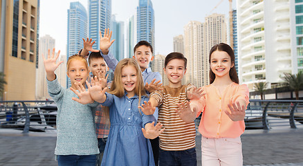 Image showing group of happy children waving hands