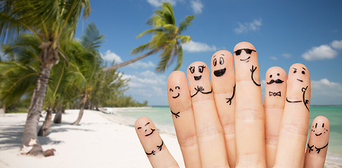 Image showing close up of fingers with smiley faces on beach