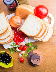 Image showing top-view of a wood table with olives tomatoes bread