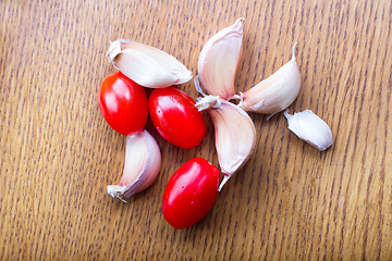 Image showing tomato garlic on a wooden kitchen table