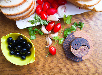 Image showing top-view of a wood table with olives tomatoes bread