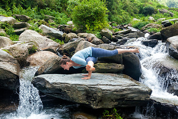 Image showing Young fit woman doing yoga oudoors at waterfall