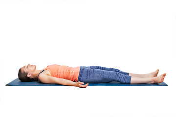 Image showing Sporty woman relaxes in yoga asana Savasana