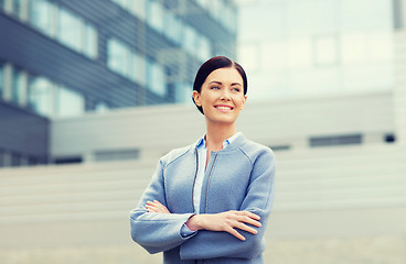 Image showing young smiling businesswoman over office building