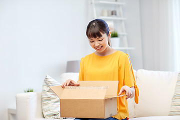 Image showing happy asian young woman with parcel box at home