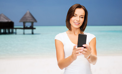 Image showing happy woman taking selfie by smartphone over beach