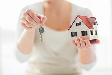 Image showing close up of hands holding house model and keys