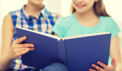 Image showing close up of happy girls reading book at home