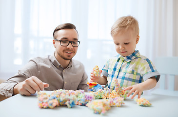 Image showing father and son playing with ball clay at home