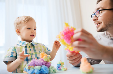 Image showing father and son playing with ball clay at home