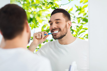 Image showing man with toothbrush cleaning teeth at bathroom