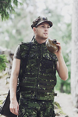 Image showing young soldier with gun and flask in forest