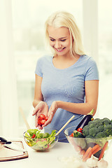 Image showing smiling woman cooking vegetable salad at home