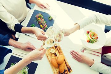 Image showing close up of women clinking champagne at restaurant