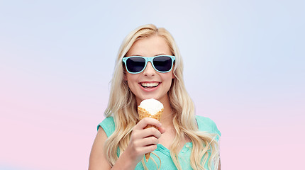 Image showing happy young woman in sunglasses eating ice cream