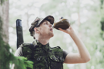 Image showing young soldier with gun and flask in forest