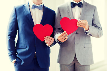 Image showing close up of male gay couple holding red hearts