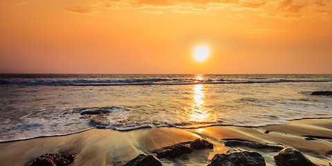 Image showing Waves and rocks on beach of sunset