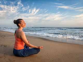 Image showing Young sporty fit woman doing yoga oudoors at beach