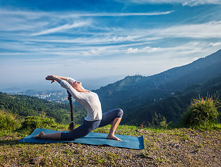 Image showing Woman practices yoga asana Anjaneyasana outdoors