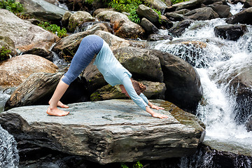 Image showing Young fit woman doing yoga oudoors at waterfall