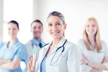 Image showing female doctor holding syringe with injection