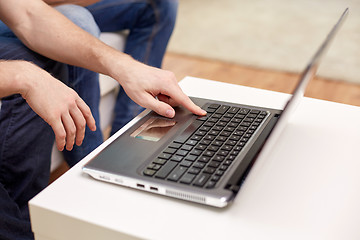 Image showing close up of male hands with laptop at home