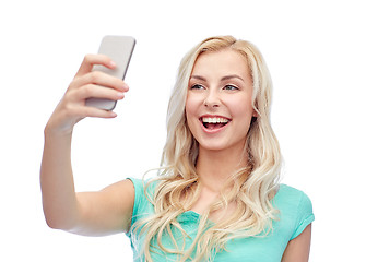 Image showing smiling young woman taking selfie with smartphone