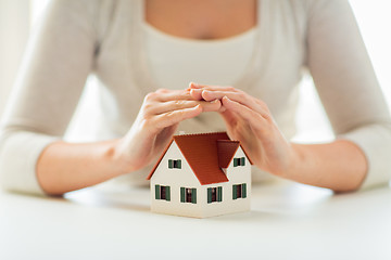 Image showing close up of hands protecting house or home model