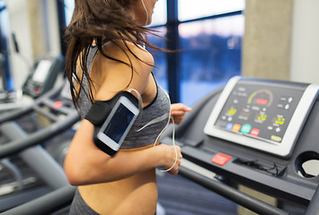 Image showing woman with smartphone and earphones in gym