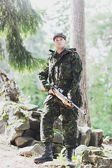 Image showing young soldier or hunter with gun in forest