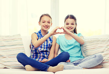 Image showing happy little girls showing heart shape hand sign