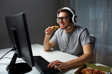 Image showing man in headset playing computer video game at home