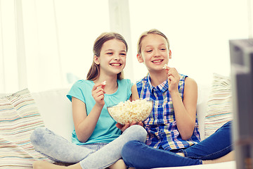 Image showing happy girls with popcorn watching tv at home