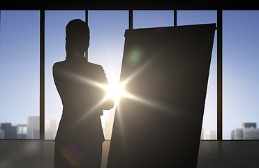 Image showing silhouette of woman with flipboard over office