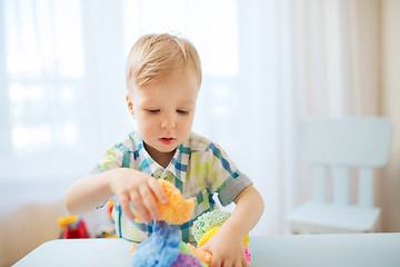 Image showing happy little baby boy with ball clay at home