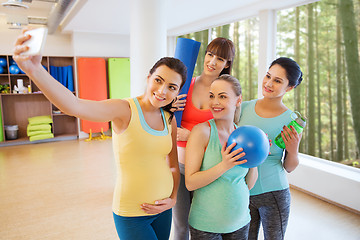 Image showing pregnant women taking selfie by smartphone in gym